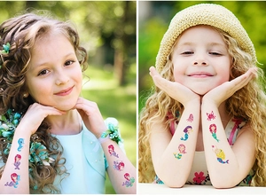 Detail von bunten Glitzer-Meerjungfrau-Tattoos für Kinder, auf Kinderarmen aufgetragen