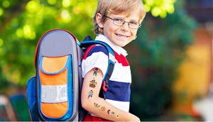 Detailed view of colorful pirate glitter tattoos applied on a child's arm outdoors
