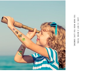 Waterproof pirate temporary tattoos on child's arm in a fun beach exploration scene