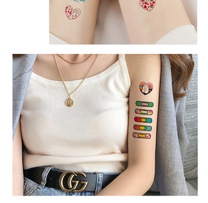 Close-up of colorful cartoon heart and rainbow temporary tattoo stickers on skin