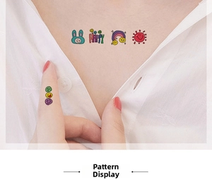 Close-up of colorful cartoon temporary tattoos with rainbow and rabbit on collarbone