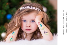Detail of glitter mermaid temporary tattoos with Birthday Girl text on child arm