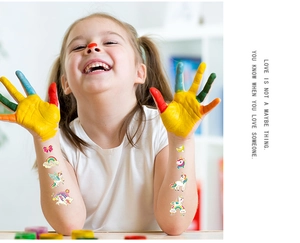 Detail of colorful unicorn temporary tattoos on a smiling girl's arm for parties