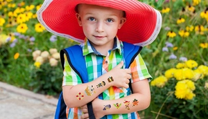 Gros plan d'un enfant portant des tatouages temporaires de pirates colorés en plein air