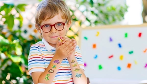 Close-up of colorful cartoon dinosaur temporary tattoos on child's arm with vibrant details