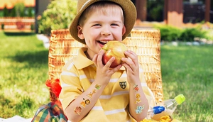 Close-up of laser gold cartoon animal tattoo stickers on a child's arm in a sunny park