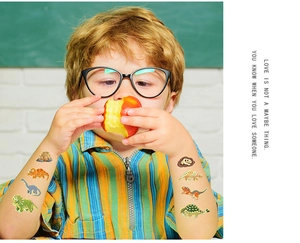 Child wearing colorful cartoon dinosaur temporary tattoos on arm during a snack break