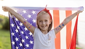 Smiling girl showing USA flag temporary tattoos for Independence Day party events