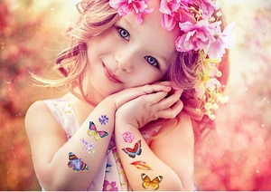 Détail de tatouages de papillons et roses colorés sur la main d'un enfant