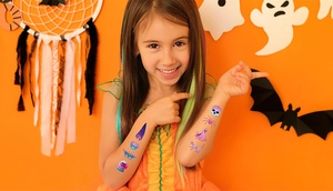 Close-up of glitter Halloween temporary tattoos with cartoon skull and ghost on child's arm