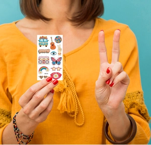 Detail view of hippie peace waterproof temporary tattoos with guitar and rainbow designs