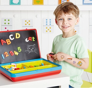 Child using magnetic learning box with colorful alphabet and number tiles for education