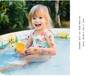 Waterproof school theme cartoon temporary tattoos on a child arm by the pool
