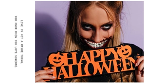 Detail of orange felt Halloween pumpkin sign held by model with spooky mouth makeup