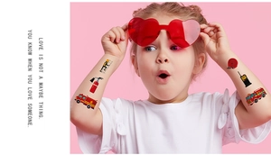 Close-up of waterproof fire truck temporary tattoos on a child arm with firemen patterns