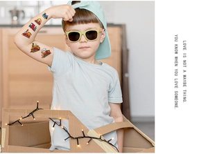 Detailed view of colorful cartoon train tattoos on a child's arm for party decoration