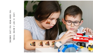Detailed view of colorful cartoon train and construction vehicle tattoos on a child's face