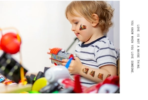 Toddler's arm showing colorful cartoon train temporary tattoos for kids party fun