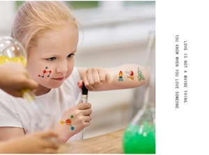 Close-up of children wearing science themed temporary tattoos with flasks and molecules