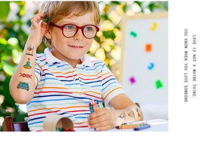 Close-up of waterproof science themed temporary tattoos on a child's arm with DNA and flasks
