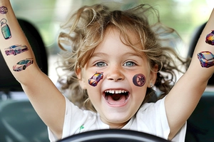 Fillette montrant des tatouages temporaires de voitures de course sur son bras et son visage
