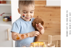 Detailed view of child wearing waterproof cartoon cupcake and coffee temporary tattoos