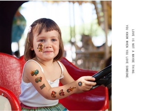 Close-up of kids waterproof racing car temporary tattoos on child arm and cheek