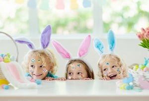 Detailed view of children wearing Easter glowing rabbit and egg tattoo stickers on faces