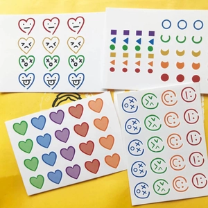 Lot de tatouages temporaires cœurs et sourires colorés sur fond jaune vif
