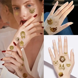 Golden metallic animal and celestial tattoo stickers on female face and hand skin