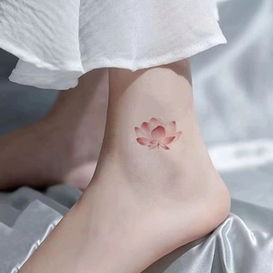 Waterproof pink lotus temporary tattoo sticker applied to ankle with watercolor effect