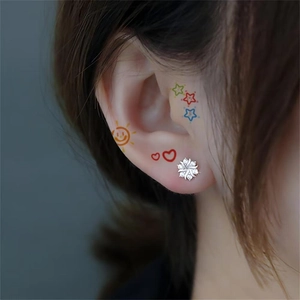 Sparkling silver flower stud earrings with cubic zirconia stones on model's ear