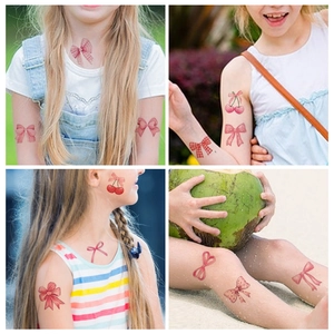 Pink ribbon and cherry temporary tattoos set on child model face and arms