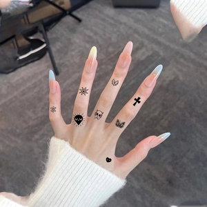 Long stiletto press-on nails with macaron gradient, gold foil, and finger tattoo stickers