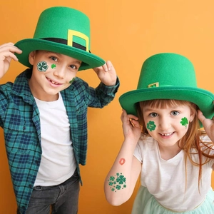 Children wearing St. Patrick's Day green clover glitter tattoos with Irish party hats