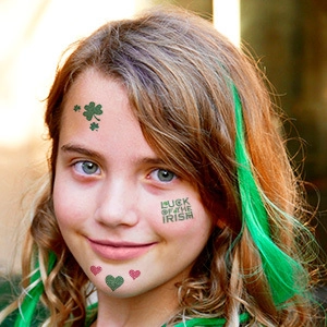 Macro shot of glittery St. Patrick's Day clover tattoo and Irish luck text on skin