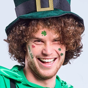 Smiling man wearing green Irish festive hat with shamrock face tattoo and 100% Irish decal