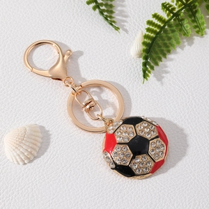 Close-up of sparkling rhinestone soccer keychain with red black enamel and gold clasp