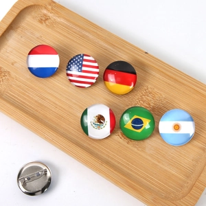 Detail van vlaggenpins in glazen cabochons met stevige metalen veiligheidsspelden