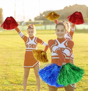 Macro shot of colorful metallic cheerleading pom poms in red gold blue and green