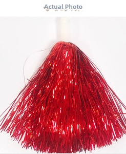 Macro detail of red metallic streamers with white plastic handle for cheerleading poms