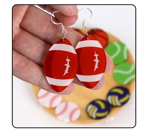 Détail de boucle d'oreille rugby en acrylique rouge et blanc avec crochets argentés