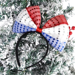 Close-up of patriotic red white and blue sequin bow headband on a snowy tree