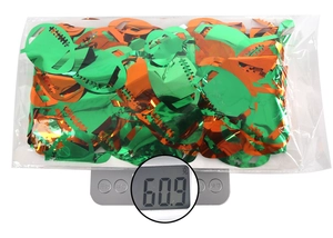 Detailed view of green and orange football confetti pack on scale weighing 60.9g