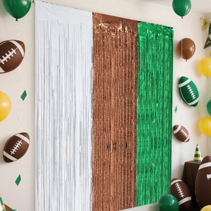 Football party foil fringe curtains in white, brown, and green for Super Bowl backdrop decor