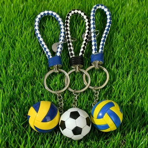 Three-piece sports keychain set with football and volleyball charms on green grass