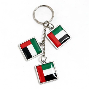 Detail of UAE flag metal keychain with three square pendants on a white background