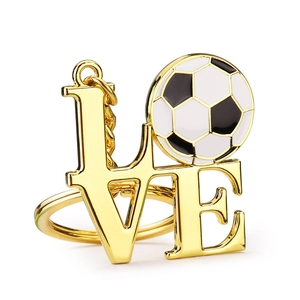Golden metal World Cup football keychain with creative LOVE lettering on white background