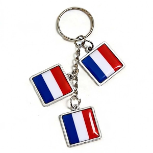 Detailed view of metal keychain with three square French flag pendants and polished finish