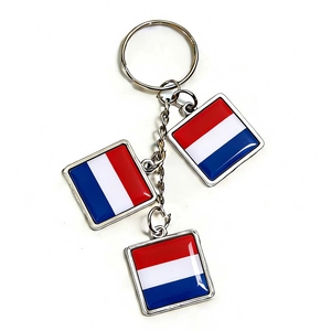 Close-up of metal keychain with three Dutch flag pendants featuring red white and blue stripes